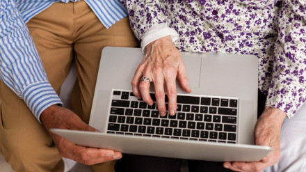 Una pareja mayor consulta internet desde su ordenador portátil