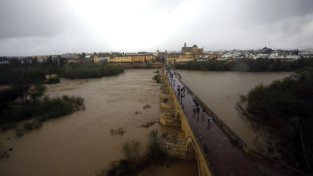 CÓRDOBA, 11/03/2025.-Vista de la crecida del río Guadalquivir a su paso por el Puente Romano de Córdoba con la Mezquita-Catedral al fondo, este martes cuando la Policía Local de ha precintado la pasarela peatonal que discurre bajo este puente y hasta Miraflores ante la crecida experimentada por el río a su paso por la capital cordobesa. EFE/Salas