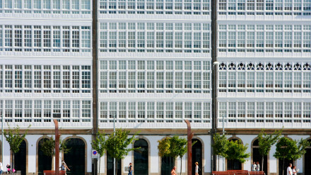 Gente paseando por la Marina, en A Coruña, con las galerías al fondo