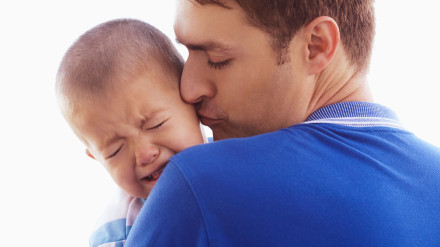 Padre besando a su hijo llorando