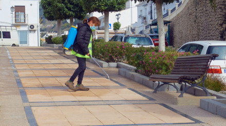 Una trabajadora rocía desinfectante en el pavimento para combatir el Covid-19 en el pueblo turístico encalado de Frigiliana, Málaga.
