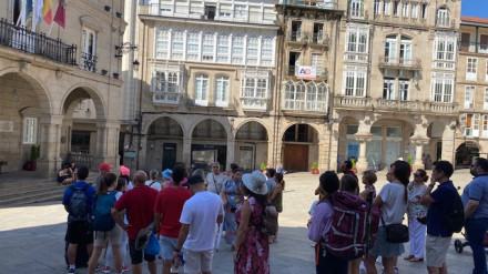 Los turistas visitan el centro histórico de la ciudad y acuden a pedir información a la oficina de turismo