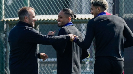 Hansi Flick habla con Raphinha y Araujo durante un entrenamiento del Barcelona.
