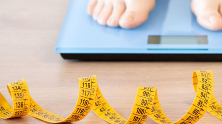 Un persona se pesa en una báscula