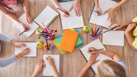 Niños en una escuela dibujando alrededor de una mesa
