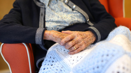 Las manos de una anciana en un hogar de ancianos.