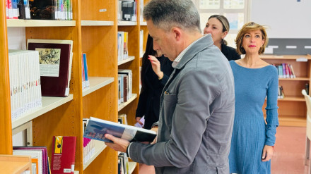 El alcalde hojea uno de los libros en la nueva biblioteca pública San José