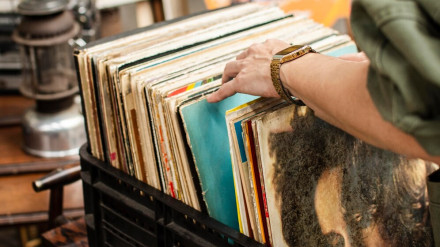 Un hombre revisa una colección de discos en una feria