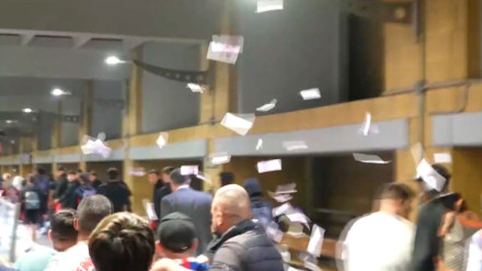 Aficionados del Sevilla lanzan billetes a los futbolistas a su llegada a la ciudad.