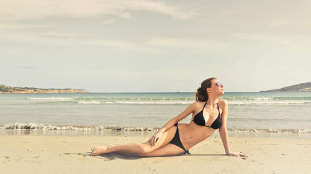 Una chica toma el sol en la playa