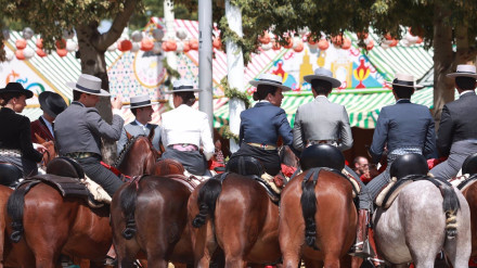 Una imagen típica del recinto ferial de Sevilla con los caballistas haciendo una parada en una de las calles del Real de Los Remedios
