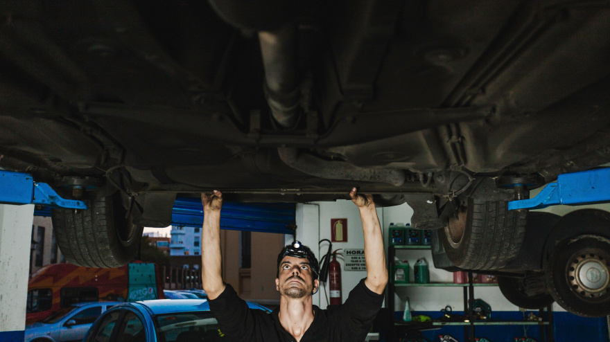 Mecánico examinando el coche en el taller