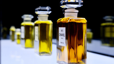 Primer plano de botellas del famoso perfume Chanel N.° 5 sobre una pizarra blanca brillante.
