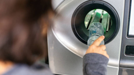 Woman at the reverse vending machine recycle plastic bottles, ecology concep