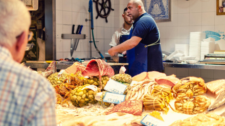 Pescadero en el mercado de Triana preparando pescado para un jubilado