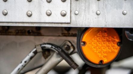 Las luces marcadoras redondas de color naranja señalan con una flecha de encendido en el lateral del semirremolque grande de aluminio.