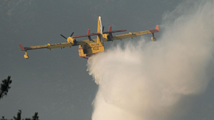Un hidroavión descarga agua sobre un incendio forestal