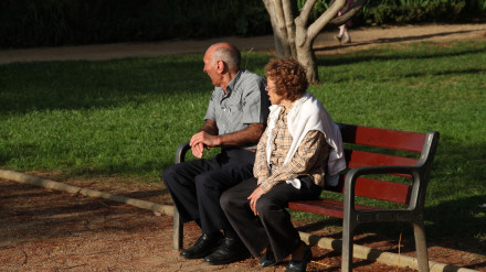 Pareja de jubilados sentados en un banco del parque, Montjuic, Barcelona