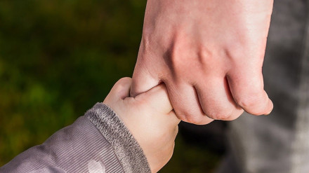 Imagen de recurso de un niño de la mano de un adulto