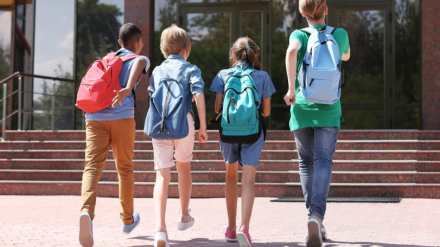 Cuatro niños entrando en su centro escolar