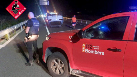 Uno de los vehículos implicados en el accidente, completamente volcado sobre la calzada de la N-332 a su paso por Benissa