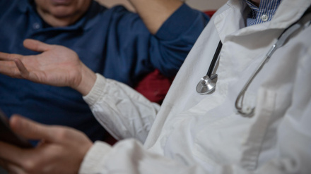 Primer plano del estetoscopio de un médico durante una visita a un paciente mayor