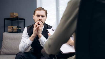 Paciente sentado en el diván durante la consulta del psicólogo.
