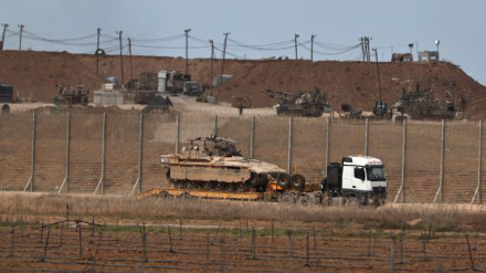 Un camión militar israelí que transporta vehículos blindados de transporte de personal sale de la Franja de Gaza tras el anuncio de Trump sobre el acuerdo entre Israel y Hamás.