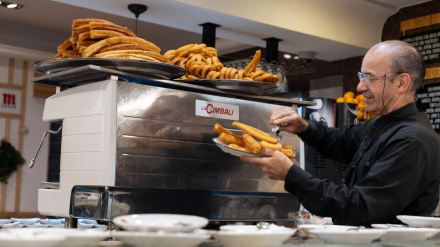 Un camarero sirve churros y porras tradicionales en Madrid