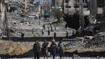 . Palestinos caminan por una calle entre los escombros de los edificios destruidos durante un alto el fuego entre Israel y Hamás, en el marco de la primera fase del plan de paz para Gaza, en la Ciudad de Gaza, Franja de Gaza