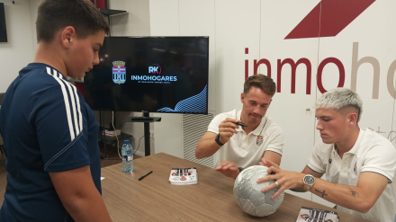 Larrea, junto a Kevin en un acto con la afición, firma el balón de Miguel