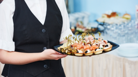 Foto de archivo de una camarera con una bandeja