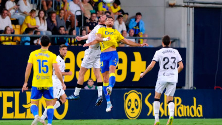 Un jugador de cada equipo pelea por un balón aéreo durante el Cádiz-Burgos