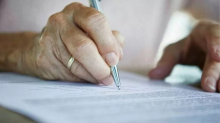 Un jubilado firma un documento