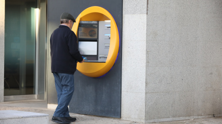 Un hombre ingresa dinero en un cajero automático