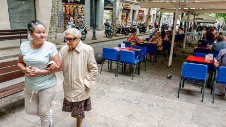 Jubiladas pasan por delante de una terraza de Barcelona