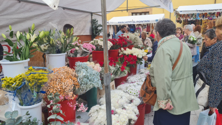 Clientes comprando flores en un puesto de el Fontán