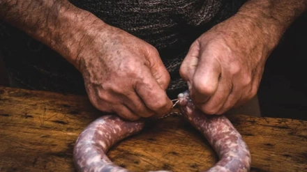 Un hombre prepara longanizas en una matanza tradicional