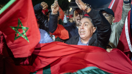 La gente ondea banderas y celebra en una calle de Rabat.