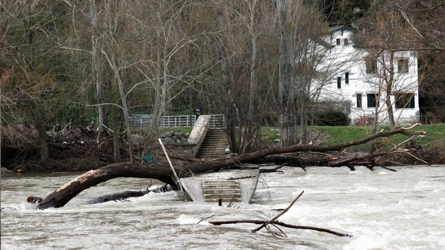 El río Arga, crecido en febrero de 2024 a su paso por las pasarelas del Club Natación en Pamplona.