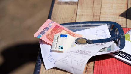 Una cuenta pagada en efectivo de bar/comida dejada en un plato de servicio con el recibo sobre la mesa del restaurante.