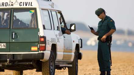 Agente de la Guardia Civil frente a un vehículo de la institución armada