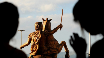 Dos personas ven una estatua de Alejandro Magno, montado en su caballo Bucéfalo en una plaza de Skopje (Macedonia).