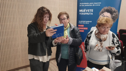 Momento en el que una técnico del Ayuntamiento ofrece ayuda una particpante del programa "Tecnomayores"