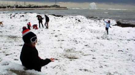 Niños jugando a la orilla del mar con la nieve que hizo acto de presencia en enero de 2017