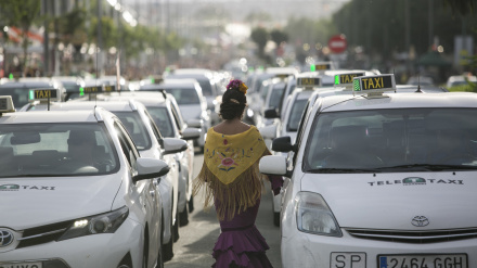 Archivo - Una flamenca circula entre taxis en la parada habilitada en la Feria de Abril, en foto de archivo.