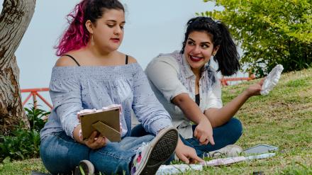 Mujeres trabajando al aire libre tomando decisiones sobre algunos objetos