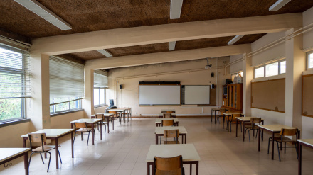 Aula vacía con pupitres muy separados.