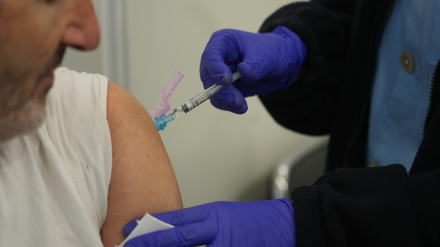 Una persona se vacuna, en un centro de refuerzo de vacunación frente a la gripe