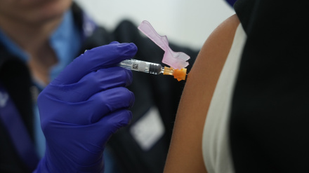 Una persona se vacuna, en un centro de refuerzo de vacunación frente a la gripe